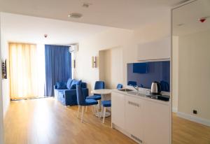 a kitchen and living room with blue chairs and a table at ORBI CITY in BATUMI in Batumi