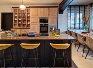 a kitchen with a large island with bar stools at Villa Basse Cour in Durbuy