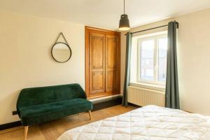 een slaapkamer met een groene bank en een raam bij Villa Basse Cour in Durbuy
