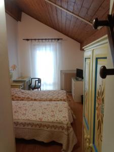 een slaapkamer met een bed en een raam bij Oberthaler Hotel in Sappada