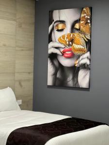 una pintura de una mujer con mariposas en su cara en Madison Suites en Cuauhtémoc
