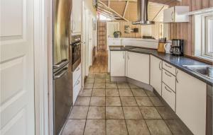 NordbyにあるAwesome Home In Samsø With Kitchenのタイルフロアのキッチン(白いキャビネット付)