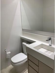佛羅安那波里的住宿－Lindo Apartamento em Jurerê com piscina，浴室配有白色卫生间和盥洗盆。