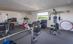 a gym with several treadmills and weights at Pukekura Motor Lodge in New Plymouth