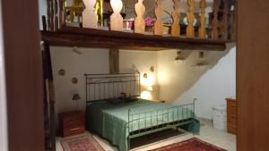a bedroom with a green bed and a staircase at La Dimora del 1700 in Tivoli