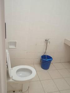 a bathroom with a toilet and a blue bucket at Putri homestay Seaview pd in Port Dickson