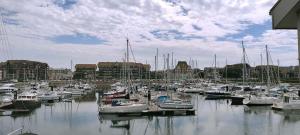 a bunch of boats docked in a harbor with buildings at Le loft-boat in Deauville