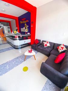 a living room with a black couch and a red wall at HOSPEDAJE PISCIS TARAPOTO in Tarapoto