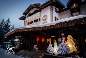 Un edificio con decorazioni natalizie sulla parte anteriore di Villa Kofler Wonderland Resort a Campitello di Fassa