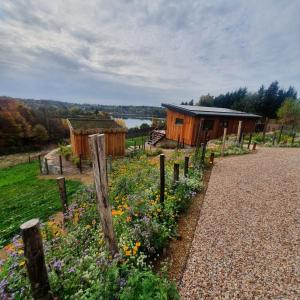 a garden in front of a wooden cabin at LAC ABANE AU LAC in Butgenbach