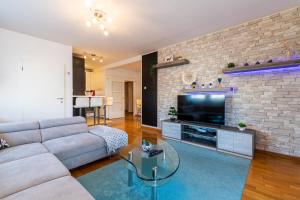 salon z kanapą i ceglaną ścianą w obiekcie Flexible SelfCheckIns 40 - Zagreb - Parking - Big Loggia - New - 2 beedroms w Zagrzebiu