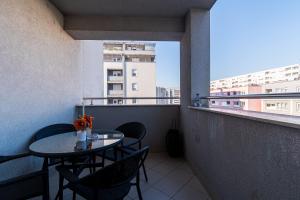 balkon ze stołem i krzesłami oraz oknem w obiekcie Flexible SelfCheckIns 40 - Zagreb - Parking - Big Loggia - New - 2 beedroms w Zagrzebiu