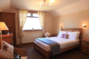 um quarto com uma cama grande e uma janela em Ardlinnhe Bed & Breakfast em Fort William