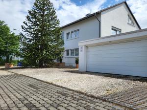 ein weißes Haus mit einem Baum und einer Garage in der Unterkunft Lounge 1 in Koblenz