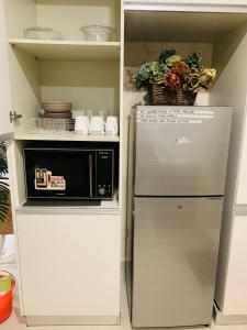 een keuken met een koelkast en een magnetron bij Elysium Service Apartment 1203 in Islamabad