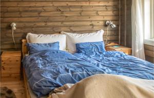 a bed with blue sheets and pillows in a bedroom at 3 Bedroom Nice Home In Oppdal in Fagerhaug