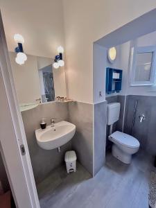 a small bathroom with a sink and a toilet at [Piazza Vittoria] Historic Netflix penthouse in Brescia