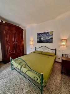 a bedroom with a green bed and a wooden cabinet at [Piazza Vittoria] Historic Netflix penthouse in Brescia