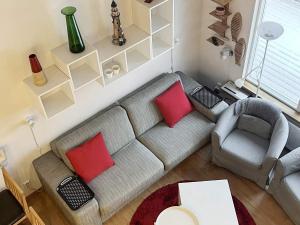 ein Wohnzimmer mit einem grauen Sofa und roten Kissen in der Unterkunft 5 person holiday home in LIDK PING in Tallbacken