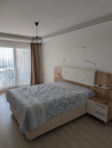 a bedroom with a bed and a large window at Vista Panorama Sunshine in Kusadası