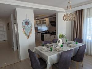 a dining room with a white table and chairs at Vista Panorama Sunshine in Kusadası