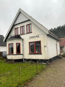 uma casa branca com janelas vermelhas num quintal em Motel Villa Søndervang twin room em Harndrup