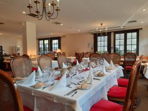 uma sala de jantar com uma mesa longa com copos e guardanapos em Hostellerie Saint Florent em Oberhaslach