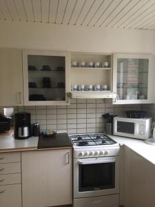 uma cozinha com um fogão e um micro-ondas em Motel Villa Søndervang twin room em Harndrup