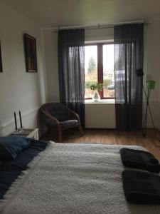 a bedroom with a bed and a window with a chair at Motel Villa Søndervang twin room in Harndrup