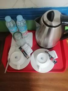 a red tray with a tea pot and plates and water at Sang Yoo Mountain View Tagaytay Bed and Breakfast - Taal Lake View in Tagaytay