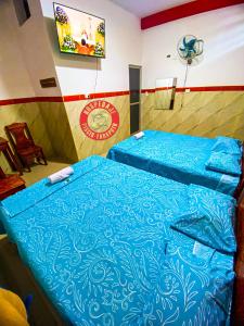 a bedroom with a bed with a blue comforter at HOSPEDAJE PISCIS TARAPOTO in Tarapoto