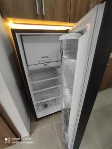 een lege koelkast met de deur open in een keuken bij Ejecutivo Loft, Con Terraza Privada, en Cali La Sucursal Del Cielo a pocos Pasos de Imbanaco in Cali
