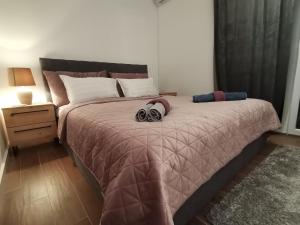 a bedroom with a large bed with two headphones on it at Apartment Novi Park Bulatovic in Vrdnik