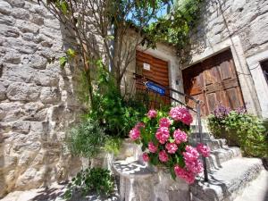 a building with a bunch of flowers in front of a door at Bluemarine Rooms & Apartments in Perast