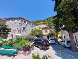 a group of cars parked in front of a building at Bluemarine Rooms & Apartments in Perast