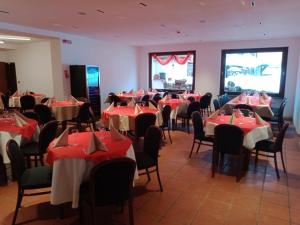 een eetkamer met rode en witte tafels en stoelen bij Oberthaler Hotel in Sappada