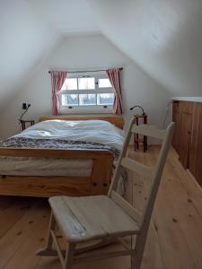 ein Schlafzimmer mit einem Bett, einem Stuhl und einem Fenster in der Unterkunft Auberge de jeunesse du Domaine à Liguori in Petite-Rivière-Saint-François
