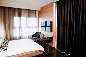 ein Hotelzimmer mit einem Bett und zwei Stühlen in der Unterkunft White Diamond in Madschdal Schams