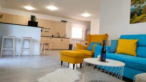 salon z niebieską kanapą i żółtymi krzesłami w obiekcie Dovolenkový dom Púpava w Tierchowej