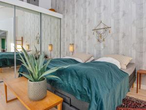 a bedroom with a large bed and a potted plant at Holiday home Silkeborg XXII in Silkeborg