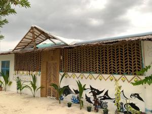 un bâtiment avec une peinture murale sur le côté dans l'établissement MANTHA VIEW, à Felidhoo 