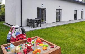 a sandbox with toys in a yard next to a house at Amazing Home In Grzybowo With Kitchen in Grzybowo