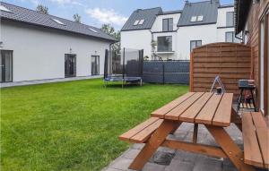 a wooden picnic table in a yard with a playground at Amazing Home In Grzybowo With Kitchen in Grzybowo