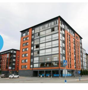 a large red brick building with a lot of windows at Pieni moderni saunallinen kaksio keskustan lähellä in Pori
