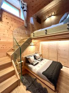 ボルミオにあるAl Bait Del Legn 1の木造キャビン内のベッド1台が備わるベッドルーム1室を利用します。