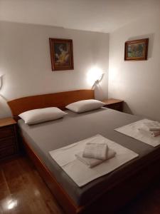 1 dormitorio con 1 cama grande y 2 almohadas en Apartments Raos en Stobreč