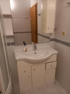 y baño con lavabo blanco y espejo. en Apartments Raos en Stobreč