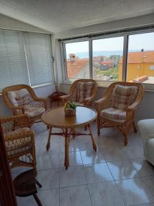 sala de estar con sillas, mesa y sofá en Apartments Raos en Stobreč