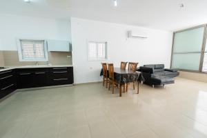 eine Küche und ein Esszimmer mit einem Tisch und Stühlen in der Unterkunft Luxury & Big Families Apartment (7 Min f TLV) in Bat Yam