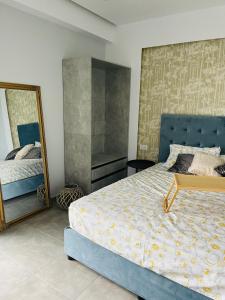 um quarto com uma cama azul e um espelho em Vixen Apartment em Theologos